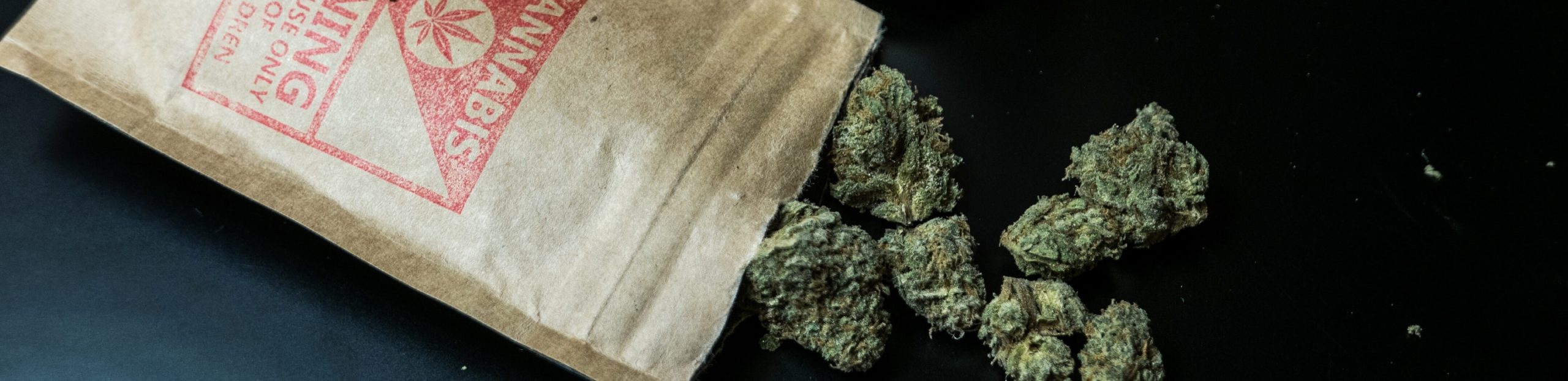 Spectrum Packaging Opened Pouches Displaying Marijuana Nuggets on Black Table